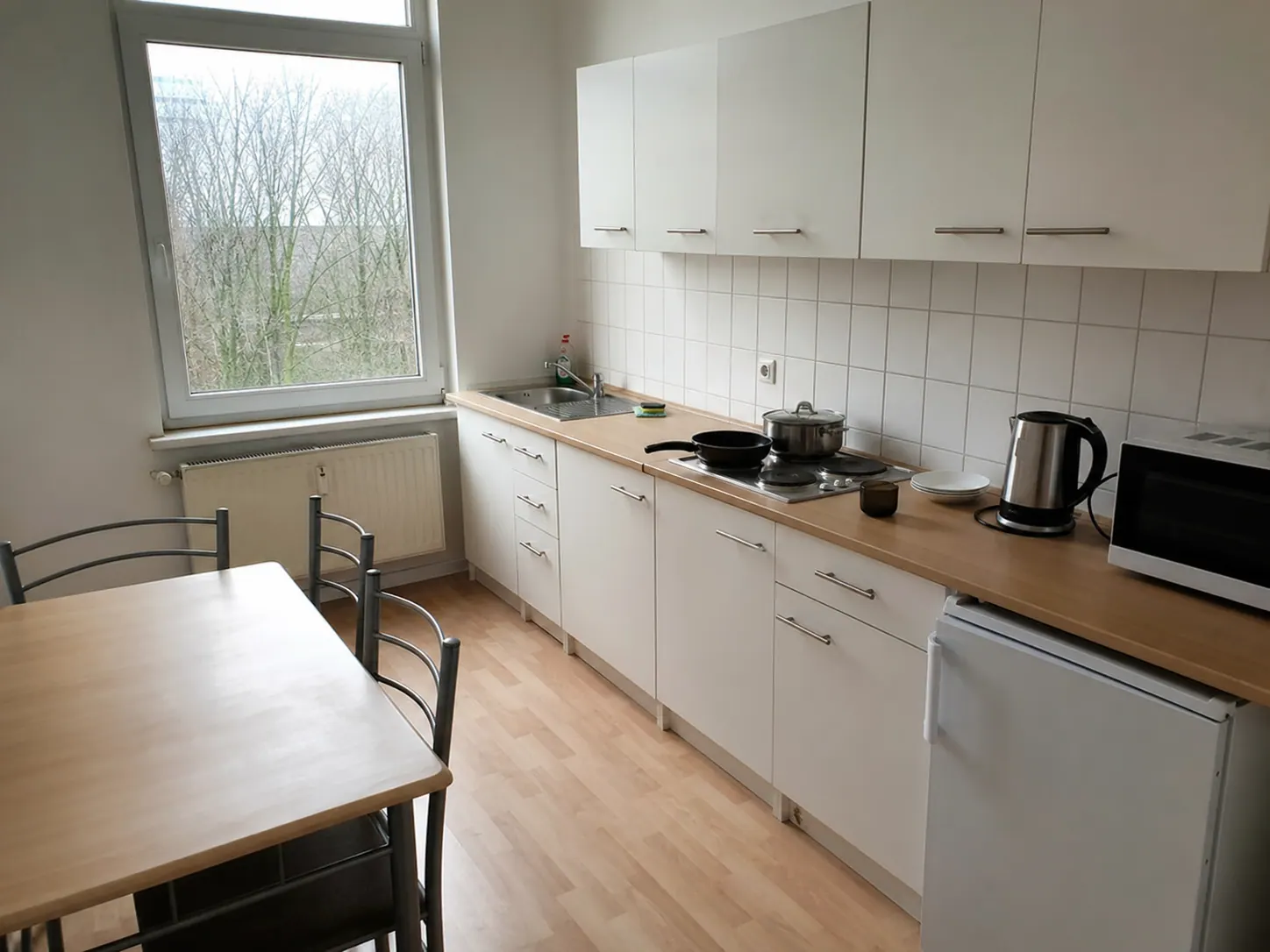 Voll ausgestattete Gemeinschaftsküche mit Herd, Kühlschrank und Mikrowelle