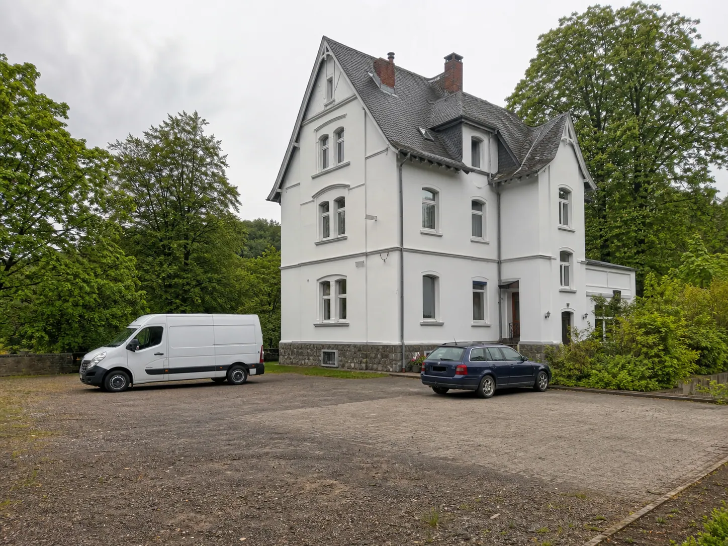Parkplatz mit Platz für Transporter und Firmenfahrzeuge vor der Villa