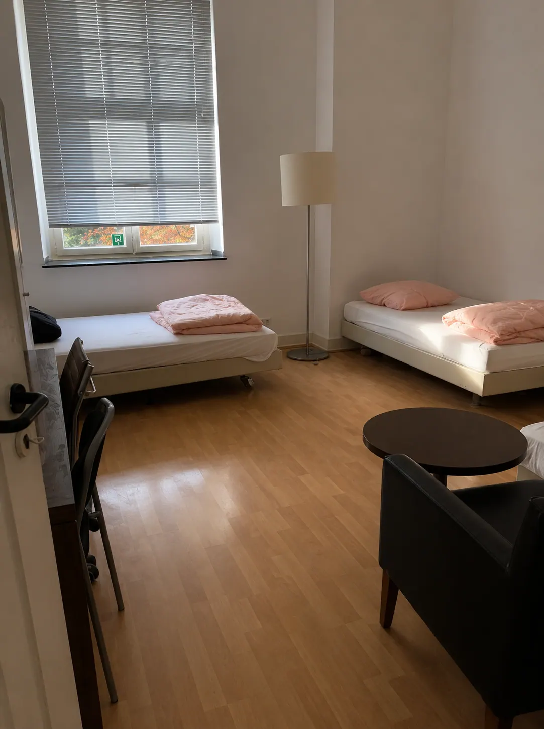 Zimmer mit zwei Betten, Sitzbereich und Tisch